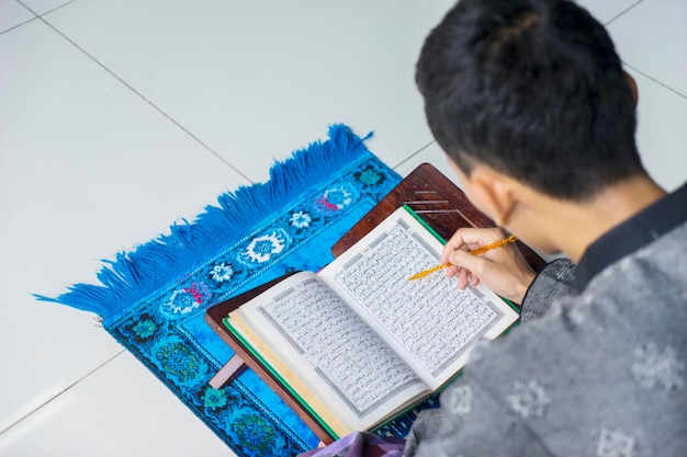 jakarta-indonesia-april-18-2018-young-muslim-man-reading-quran-ramadan-time-home_175634-19091